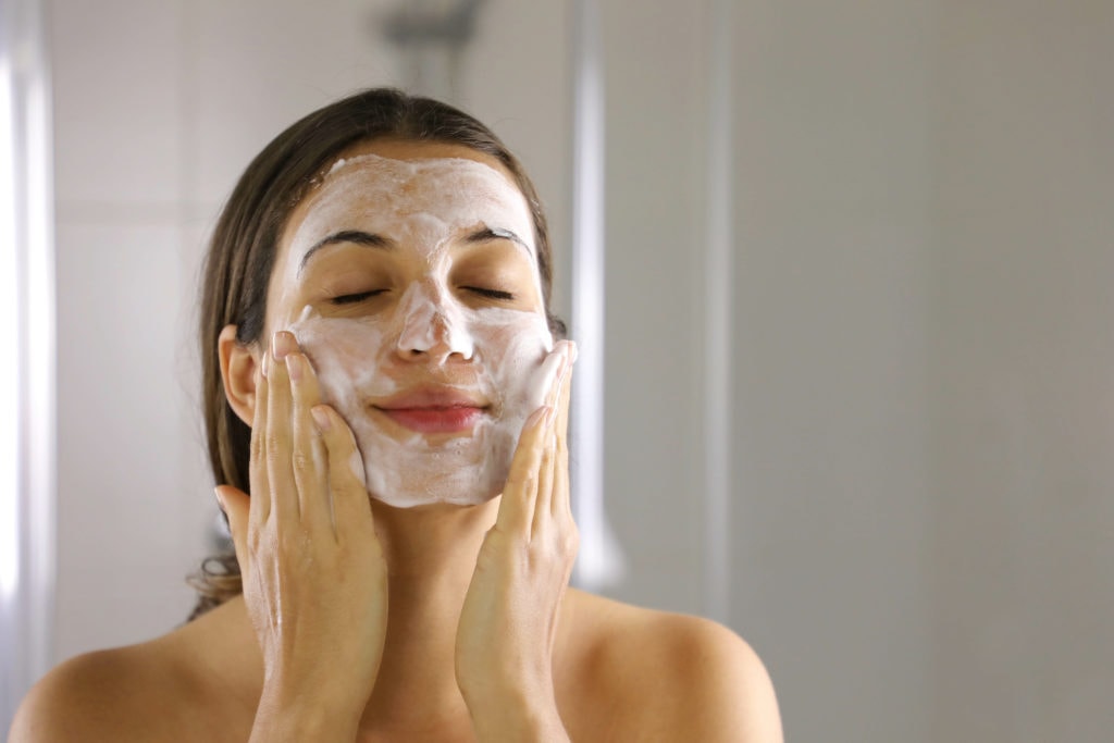 Skincare woman washing face foaming facewash soap scrub on skin