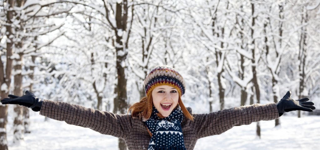 Beautiful young red-haired woman in winter park.